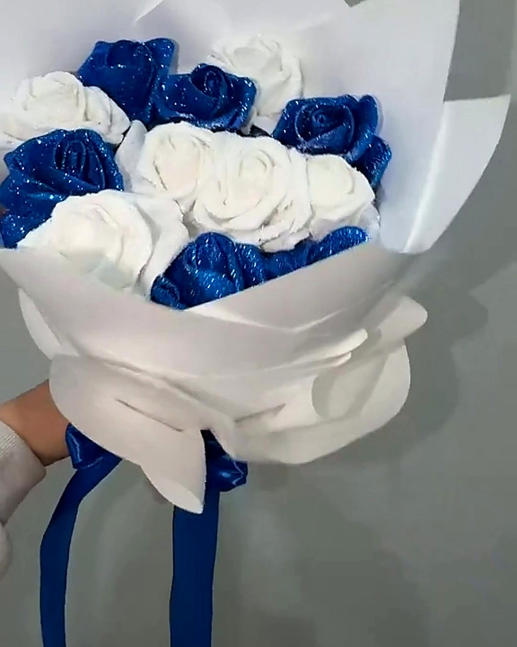Blue and White Glitter Rose Bouquet held up, white wrap